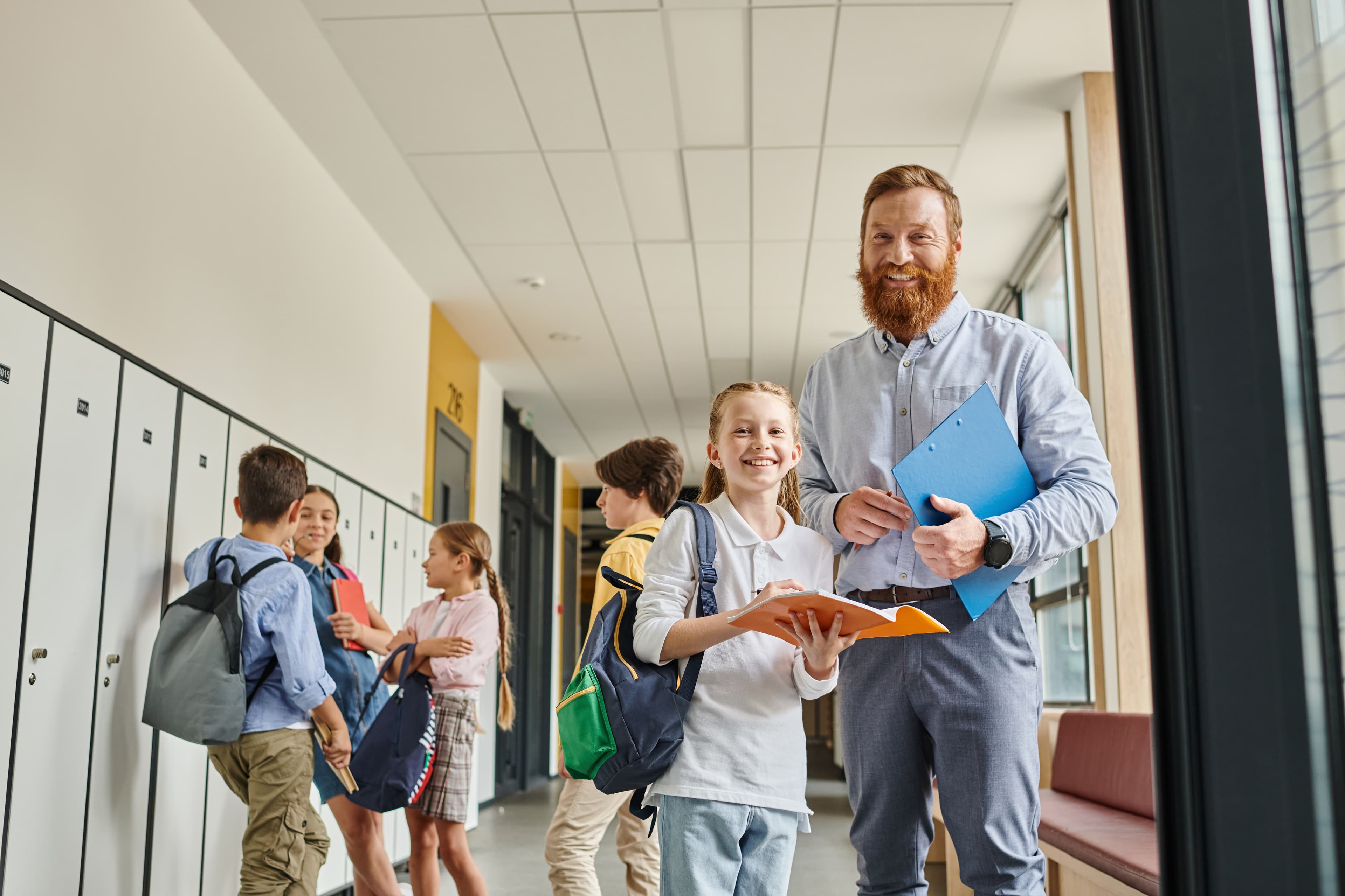 Enseignante en discussion avec des élèves dans un corridor d'école.